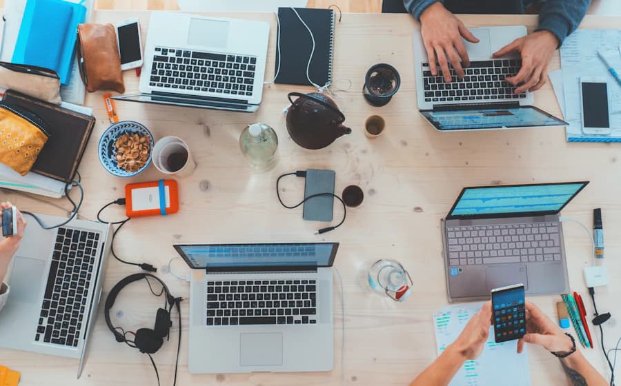 Overhead view of a shared workspace with multiple laptops and devices in use